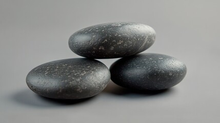 Three Stacked Smooth Stones on Grey Background