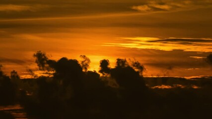 Wall Mural - time lapse of dramatic sunrise with orange sky in a cloudy day.
