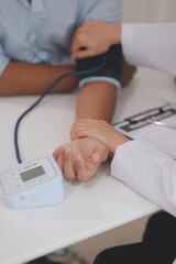 Wall Mural - The doctor woman hand use the pulse meter to measure the pressure of the patient, medical checkup concept.