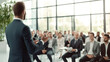 © halo - A business professional is presenting to an audience in front of them, giving a speech or presentation in a conference room.