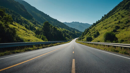 Panoramic view of a winding asphalt highway through snow-capped mountains under a clear summer sky