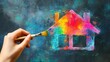 © savittree - A hand holding a paintbrush, bringing a house outline to life with a burst of vivid colors, symbolizing creativity and design.