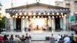 © Mari - Blurred background of an outdoor theater stage with performers.
