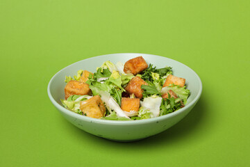 Wall Mural - Fried tofu salad on a green background