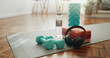© PeakPoints/peopleimages.com - Headphones, mat and dumbbells with water bottle of fitness equipment or interior on floor at home. Empty room or space with headset, weights or liquid for health, wellness or tools for exercise