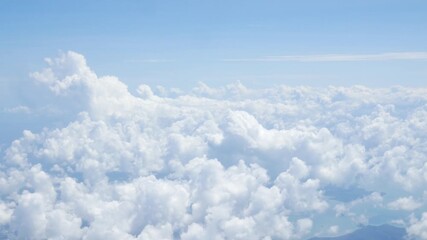 Wall Mural - view from plane over blue sky with white Fluffy clouds while flying through in sunny summer time.nature blue sky cloud and sun for Clean Environment, save energy or transportation holiday concept. 