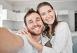 © DavisShared/peopleimages.com - Couple, portrait and selfie in house for bonding, relax and happiness with joy, embrace and fun. Man, woman and smile in living room for love, memory and social media together in lounge with hug