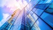 © creative - Low angle view of a modern glass skyscraper with a blue sky and clouds.