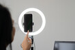 © Kunlathida - Blogger vlogger talking with followers hand holding phone in middle of selfie light round lamp