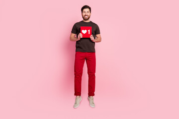 Sticker - Full length photo of positive handsome guy with stubble dressed t-shirt hold social media like jump isolated on pink color background