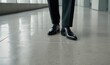 © Makaron - Elegantly dressed legs in polished shoes, standing on a modern floor. Ideal for business, finance, or corporate lifestyle themes.