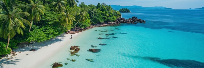 Poster - A beautiful beach with a clear blue ocean and a rocky shoreline. The beach is empty, with no people visible. The ocean is calm and inviting