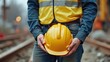 © ShahinurSobuj - Construction Worker Holding Yellow Helmet | Safety Vigilance at Industrial Worksite