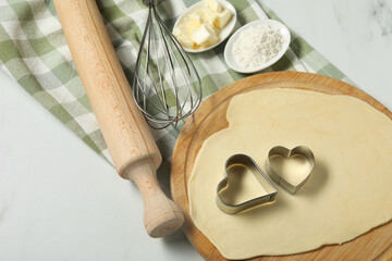 Canvas Print - Raw dough, cookie cutters, flour, butter, whisk and rolling pin on white table, above view