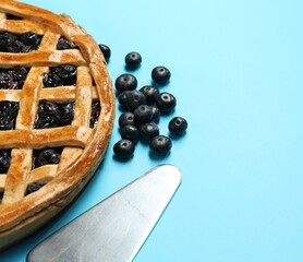 Canvas Print - Tasty homemade pie with blueberries and server on light blue table, closeup