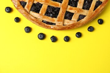 Wall Mural - Tasty homemade pie with blueberries on yellow table, top view. Space for text