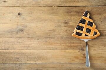 Wall Mural - Piece of tasty homemade blueberry pie and server on wooden table, top view. Space for text