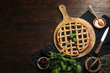 Wall Mural - Tasty homemade pie with blueberries, fresh berries, mint, honey and knife on wooden table, flat lay. Space for text