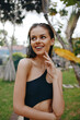 © SHOTPRIME STUDIO - Woman in a stylish black one piece bathing suit posing gracefully for a photo shoot in the park on a sunny day