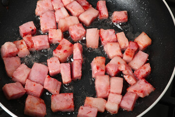 Wall Mural - Pieces of bacon frying in pan, closeup