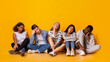 © Prostock-studio - Bored international classmates sitting over yellow studio background, being tired after classes, panorama