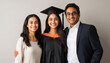 © Niks Ads - A young Indian woman in her graduation gown, posing with her arms around her parents who look happy and proud of their daughter's achievement