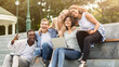 © Prostock-studio - Happy friends international students posing while studying with laptop in city, sitting on stairs, empty space