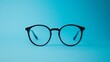 © Galib - A pair of black framed glasses against a blue background.  Simple and classic.