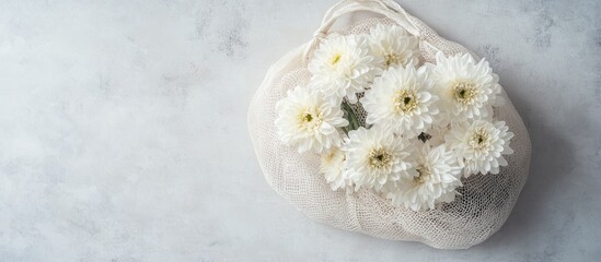 Aufkleber - White chrysanthemum flowers in a cotton mesh bag on a light backdrop Copyspace for your text
