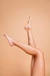 © deagreez - Cropped vertical no filter portrait of perfect model girl raise legs isolated on beige color background