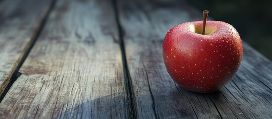 Poster - Close up of a red apple on a wooden surface with copy space