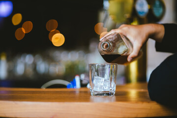 Whiskey drinks at the bar celebrating a special event in a luxury bar. Close-up shows a cheerful atmosphere as glasses clink together, reflecting a lively and joyful gathering.