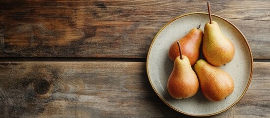 Poster - Plate with fresh pears on a wooden table. with copy space image. Place for adding text or design