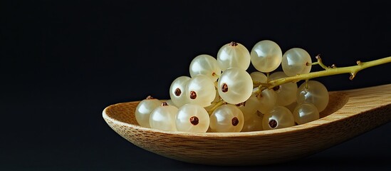 Aufkleber - White currants in a wooden spoon against a black background White currants with copy space Tasty berry
