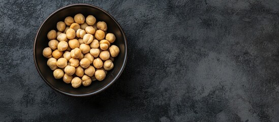 Fototapete - Bowl with macadamia nuts on dark concrete Top view. with copy space image. Place for adding text or design