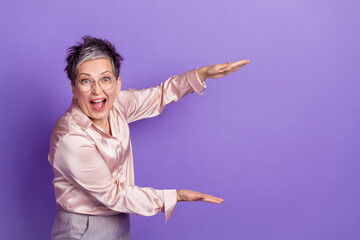 Sticker - Photo portrait of nice pensioner female hold empty space measure wear trendy satin outfit isolated on violet color background