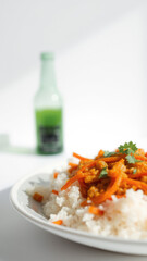 Wall Mural - Close up of rice with carrots and cilantro on a white plate