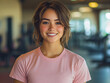 © wing - a young woman with a bright smile, posing in a gym with exercise equipment in the background.