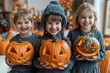 © Golib Tolibov - Three kids celebrate Halloween with pumpkins