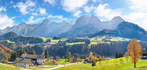 Breathtaking view of  Alpine green fields and traditional wooden houses near Abtenau village at autumn sunny day.