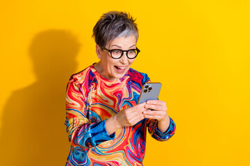 Sticker - Photo of nice aged woman use smart phone empty space isolated on yellow color background