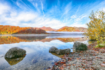 Wall Mural - captivating autumn scene of foggy and sunny morning on almsee lake.