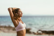 © milanmarkovic78 - Woman Stretching Before Morning Yoga Routine On The Beach