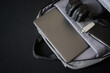 © slexp880 - Open small city backpack with laptop, headphones, USB flash drive and notepad on dark background. Travel, trips, study and lifestyle with gadgets. Copy space. Photo