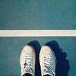 © Heng Heng - AI Stock - A pair of tennis shoes neatly placed on the baseline of a tennis court ready for a game or training session  The image has ample copy space at the top for text or branding