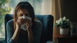 © Serhii - Girl in a chair sneezes into a handkerchief, has a cold