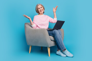 Sticker - Full body photo of nice senior woman sit armchair netbook excited wear trendy striped outfit isolated on blue color background