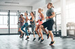 © BestCam/peopleimages.com - Sports, people and group of athletes in gym for health, wellness and body workout. Team, warm up and personal trainer challenge with active routine for cardio exercise at class in fitness center