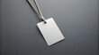 © ThomasStockArt - Empty layout on grey background. Common blank label name tag hanging on neck with thread