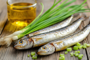 Fresh herring fish with green onions and oil on a wooden table